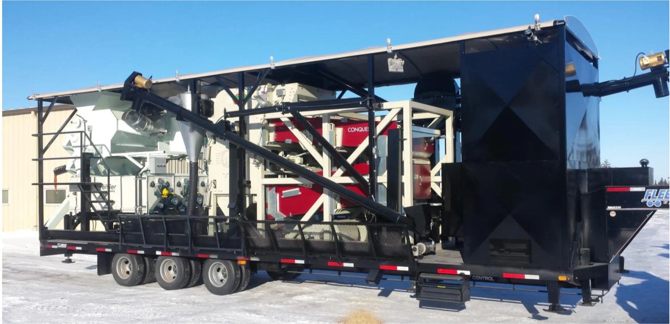 A used SMS mobile grain cleaner on a tridem step deck trailer